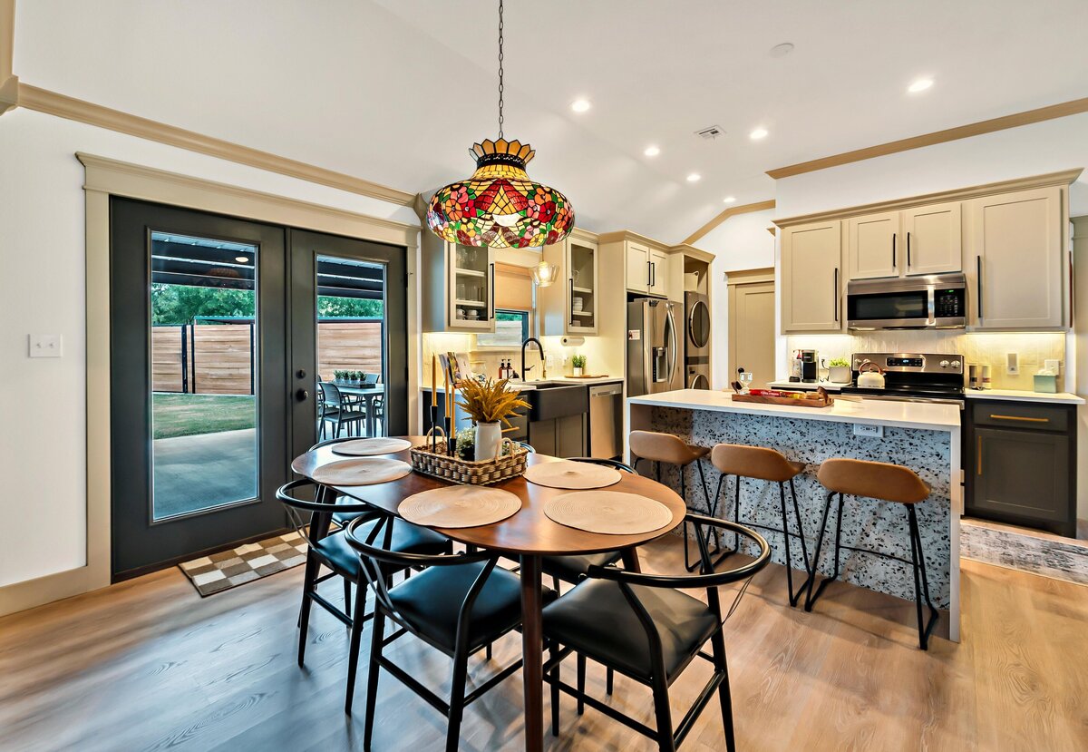 Beautiful dining table that seats six and open concept kitchen with bar seating for three in this three-bedroom, three-bathroom vacation rental home with free wifi, outdoor theater, hot tub, propane grill and private yard in Waco, TX.
