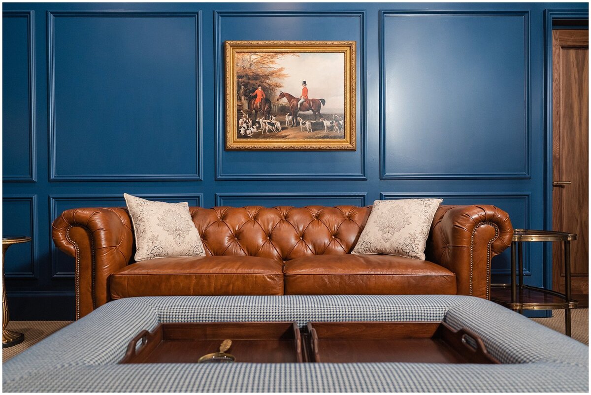 Brown leather couch against the blue wall in the grooms room