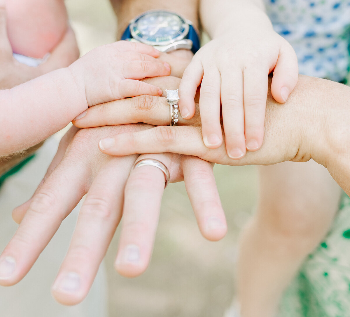A touching close-up of parents' and children's hands layered together, symbolizing love, connection, and family bonds.