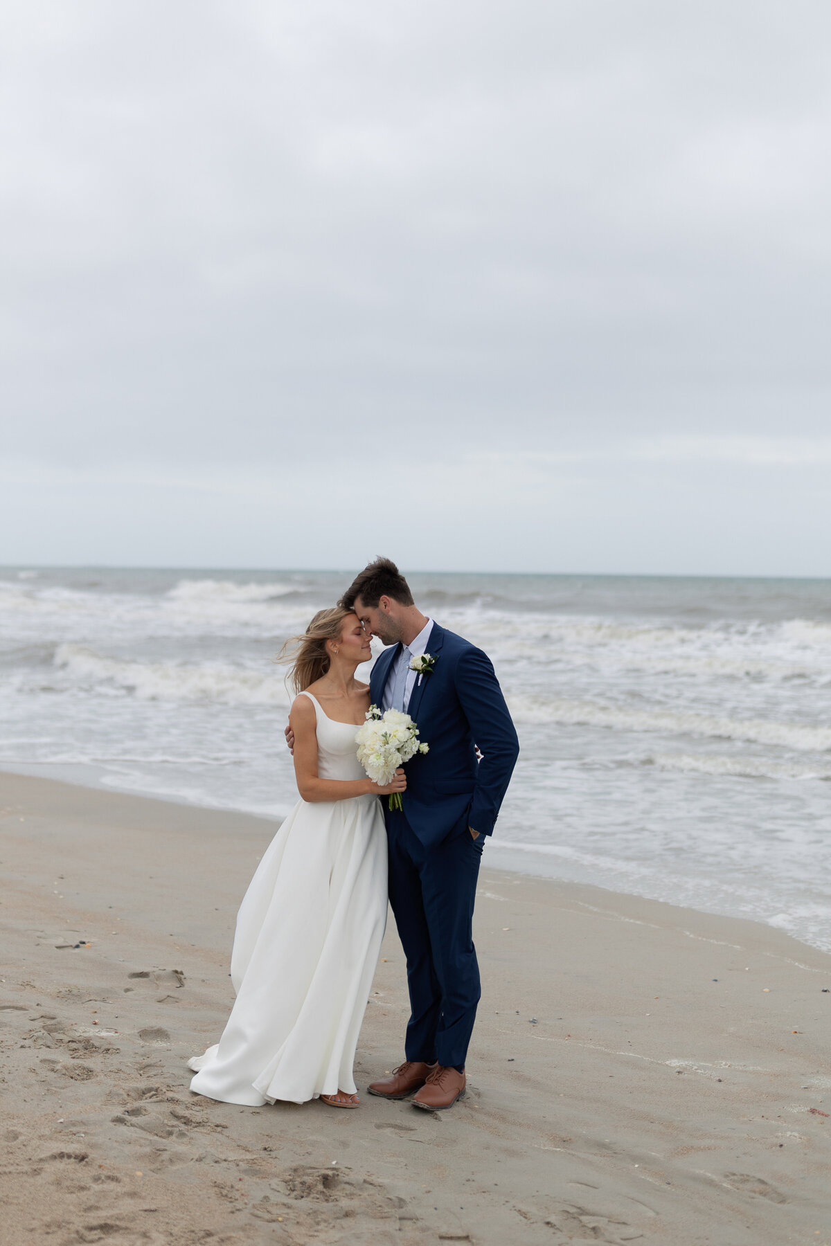 Bride and Groom pose at Emerald Isle for their coastal wedding