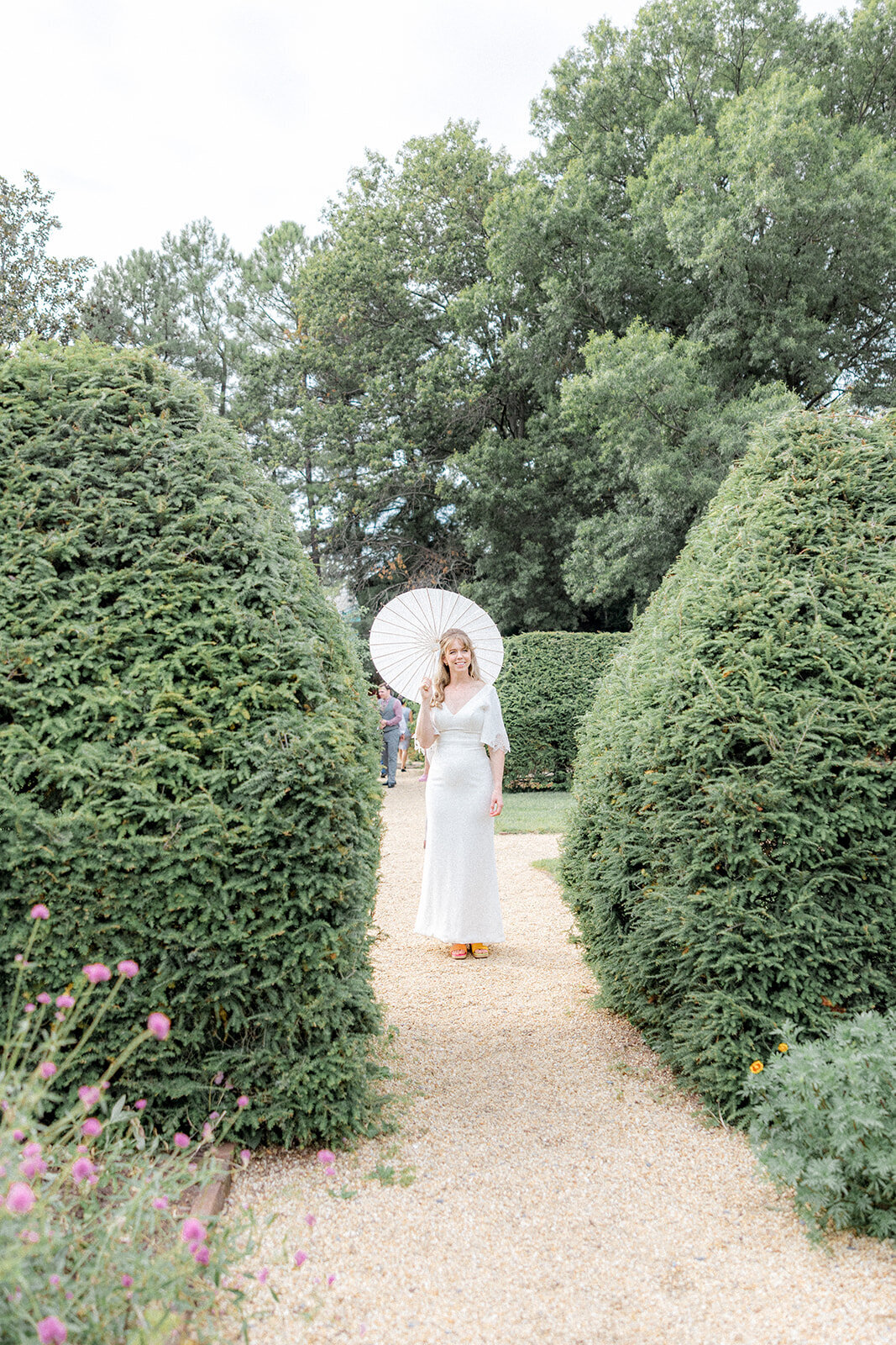 Bride holding umbrella in garden