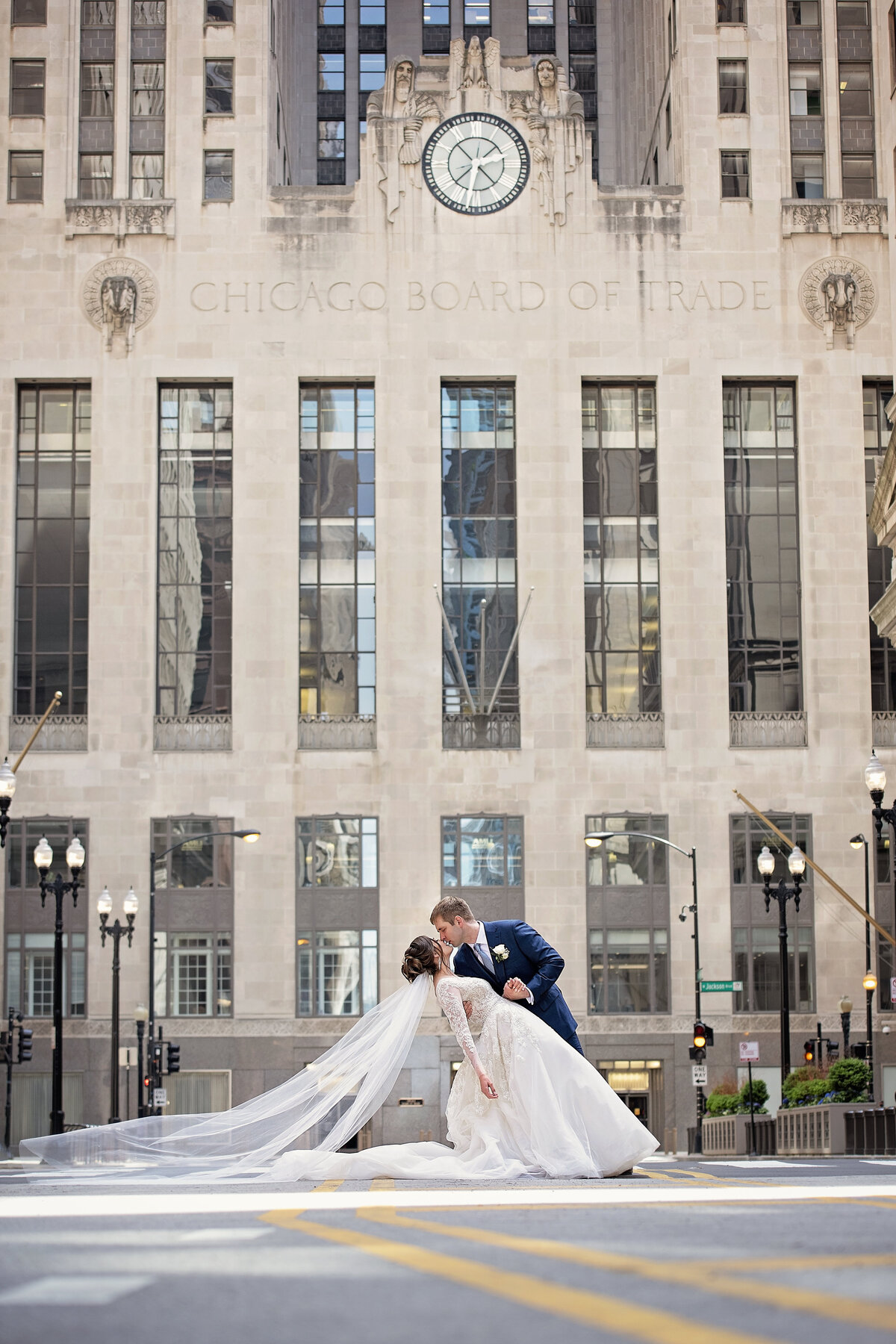 Groom dipping bride for a kiss in front of  Chicago board of Trade building