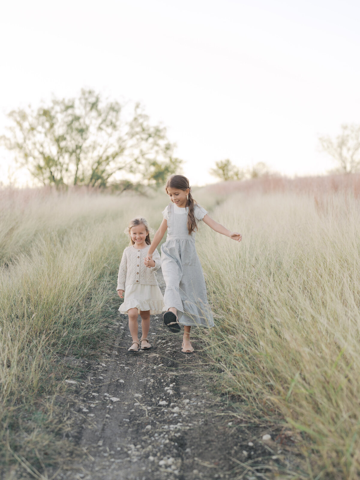 Sisters walking in field by Colorado Springs Family Photographer | Lauren Bounds