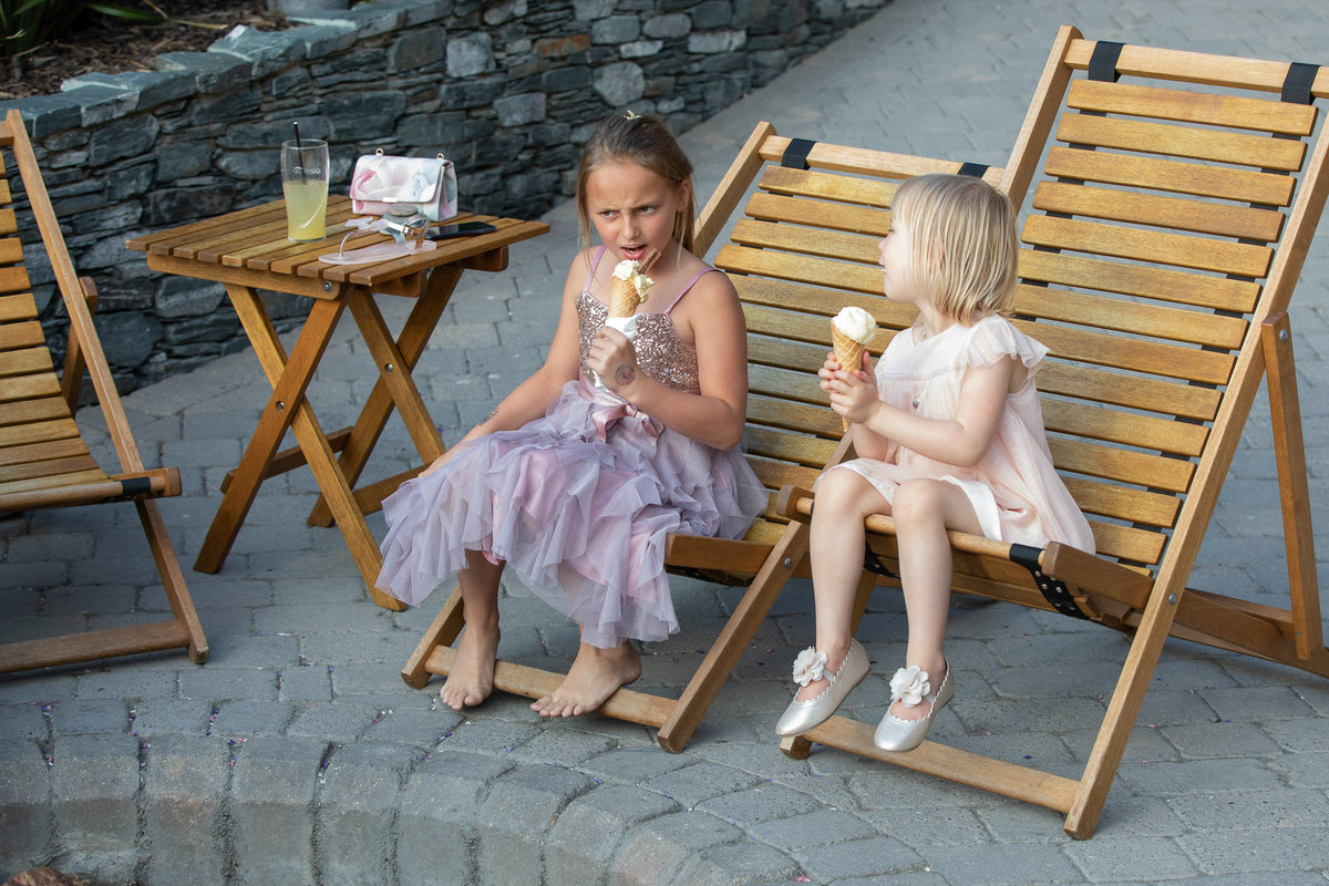 Cute flower girls talking with ice cream at Tunnels Beaches wedding venue in Devon