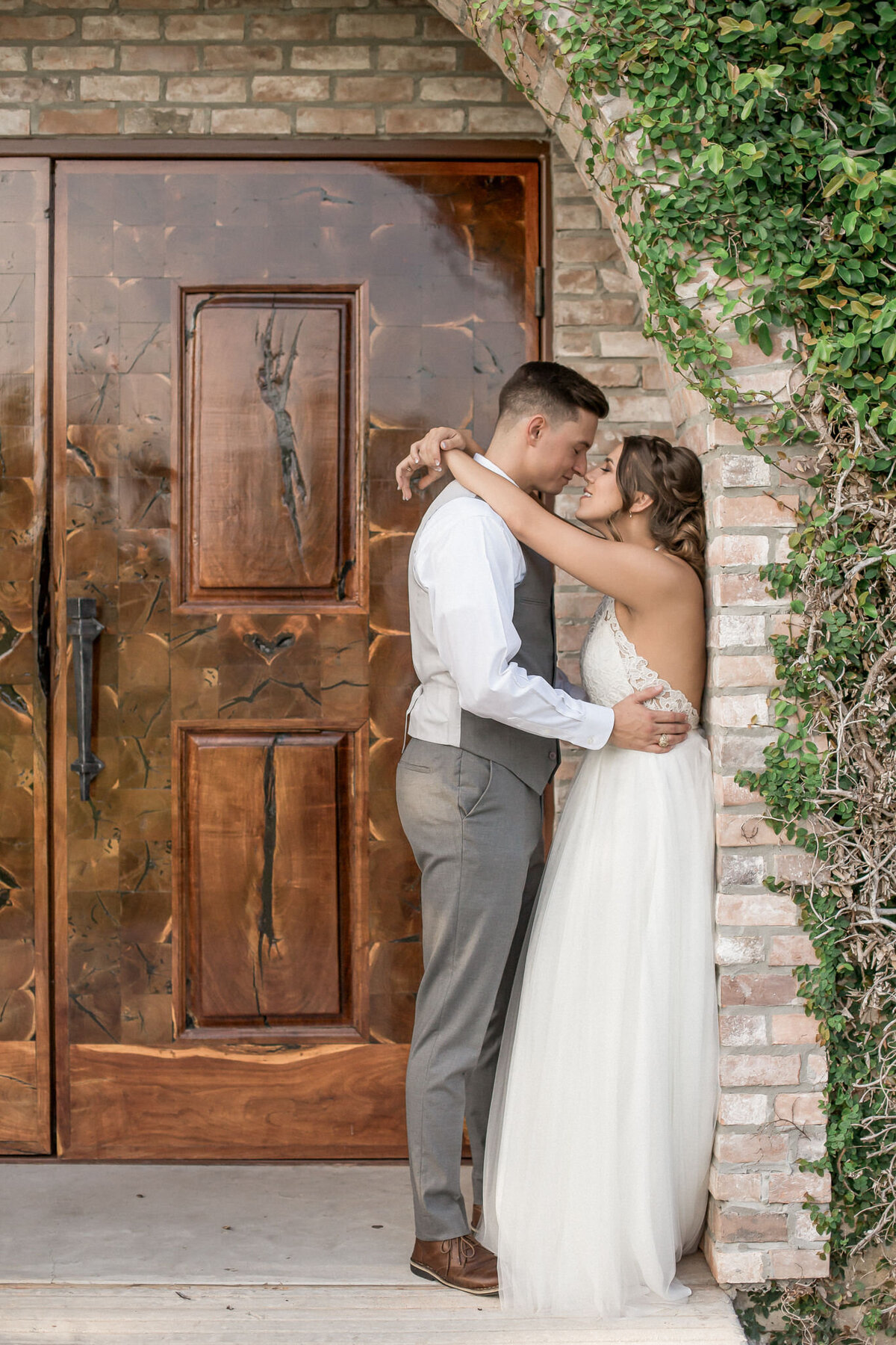 A bride embraces her groom in an intimate location outside of their wedding venue