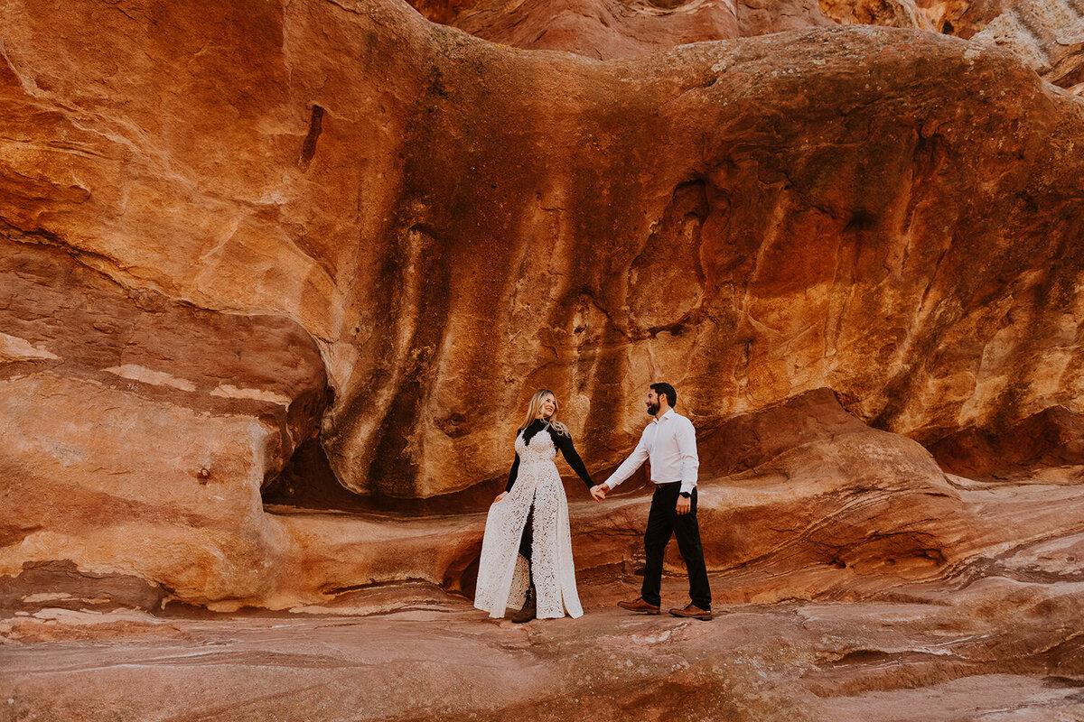 couple walking on red rock formation