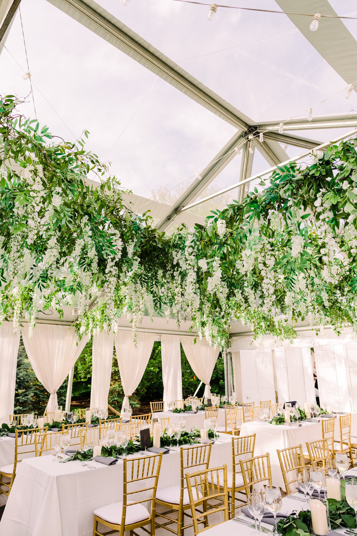 A wide-angle wedding photo of an elegant tented reception at a private estate in Naperville.