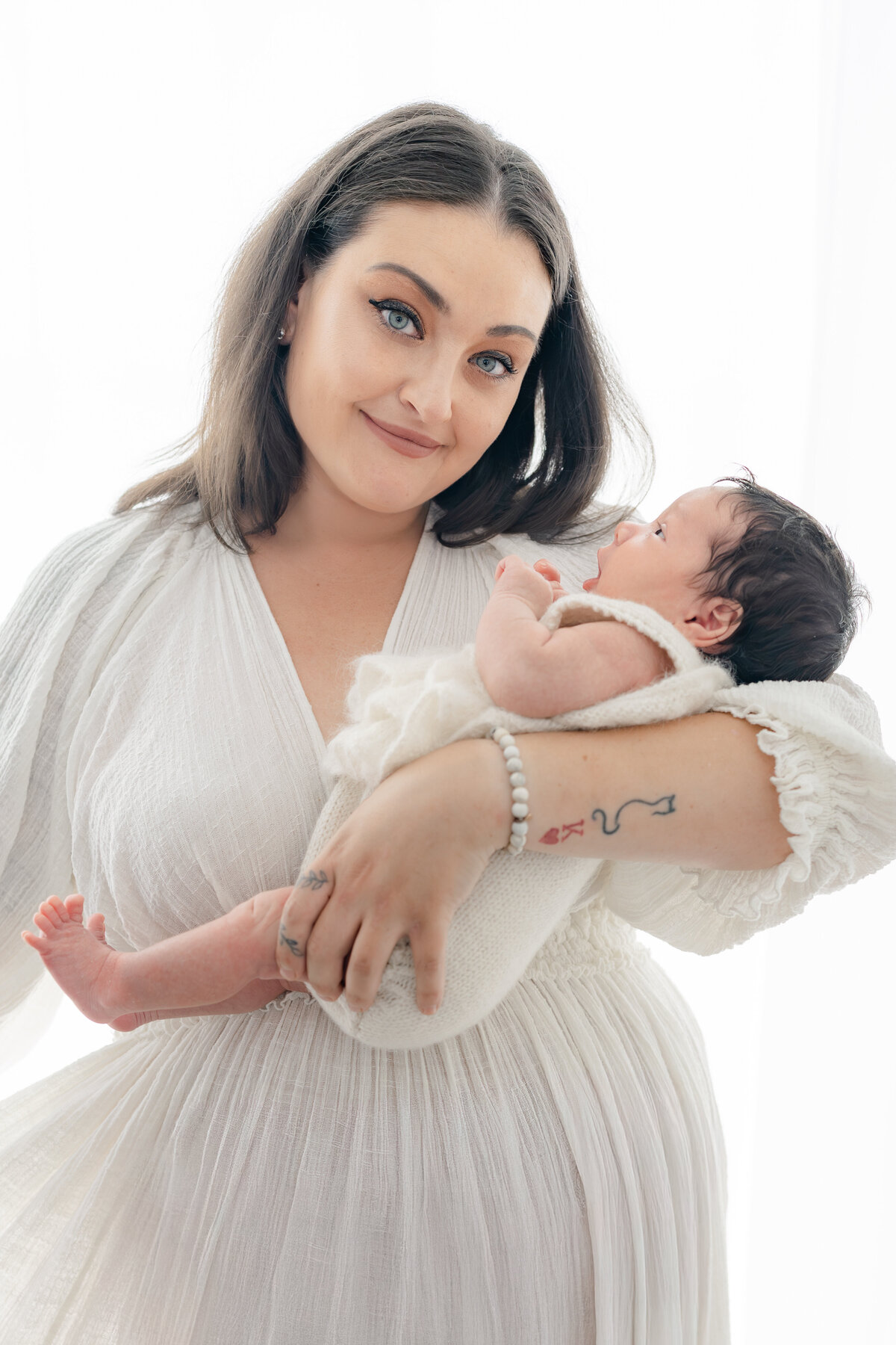 Mom holding baby during natural light Barrie newborn photography session 