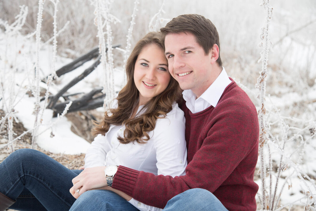 an engaged couple sitting by a frosted bush during their engagement session with las vegas wedding photography artist, Jessica Bowles