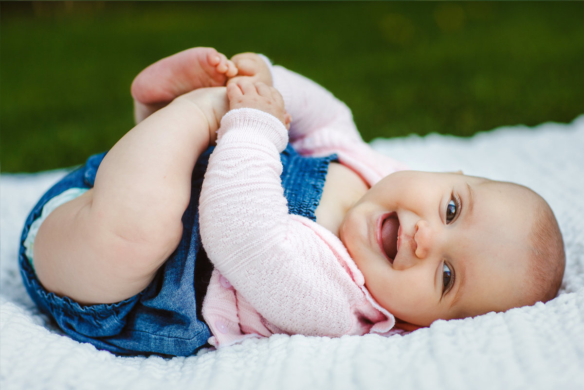 Chubby baby on blanket smiling at camera