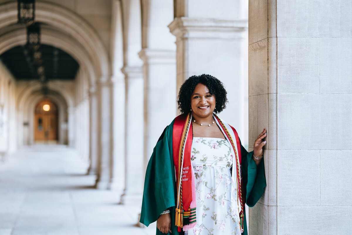 washu grad standing in the quad hallway leaning on a pillar