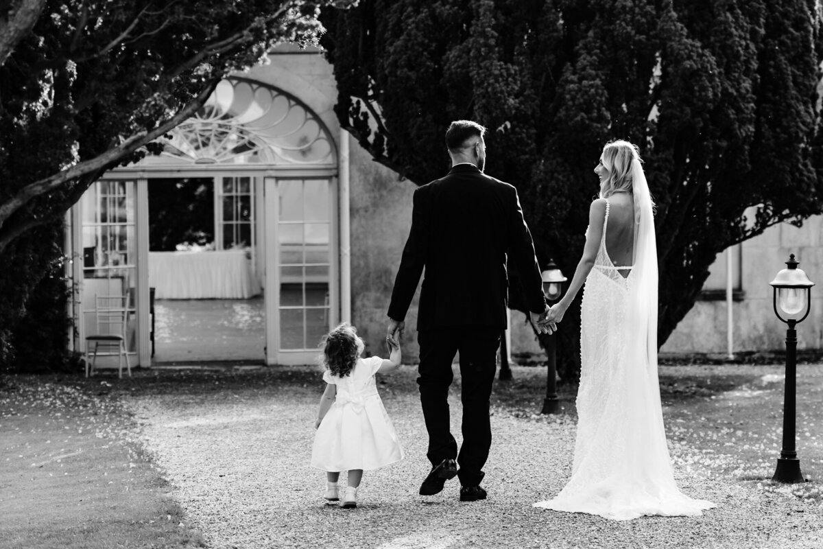 Bride and groom walk hand in hand with their daughter at Barton Hall Hotel