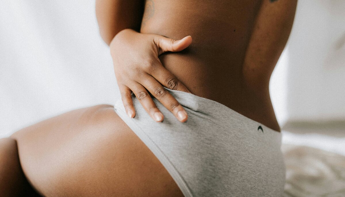 Artistic, soft-focus image of a relaxed woman lying in bed with a book, embodying the serene and personal journey of self-care promoted in Charlotte Hunter's Menopause Midsection Makeover program.