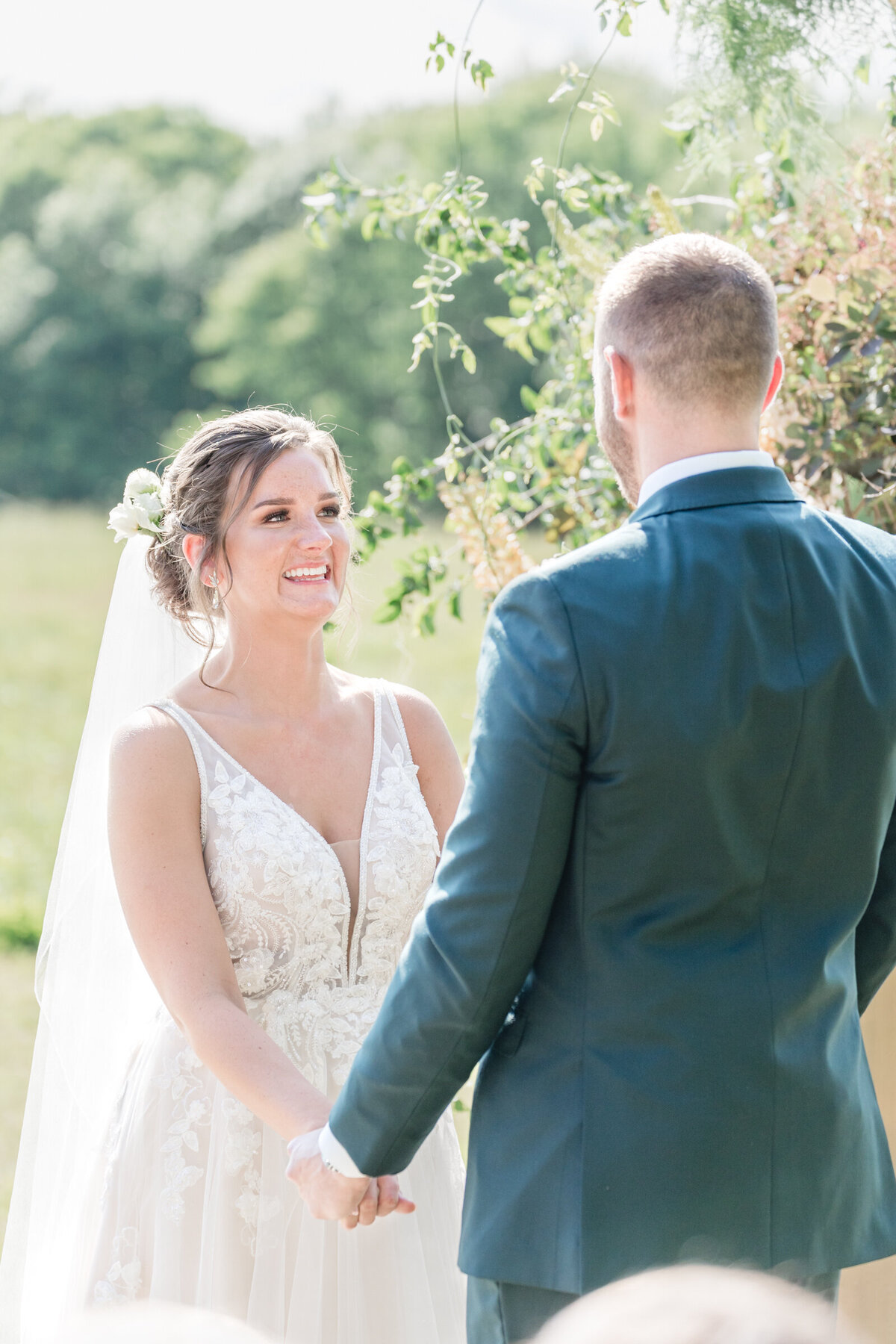A bride and groom hold hand at the alter