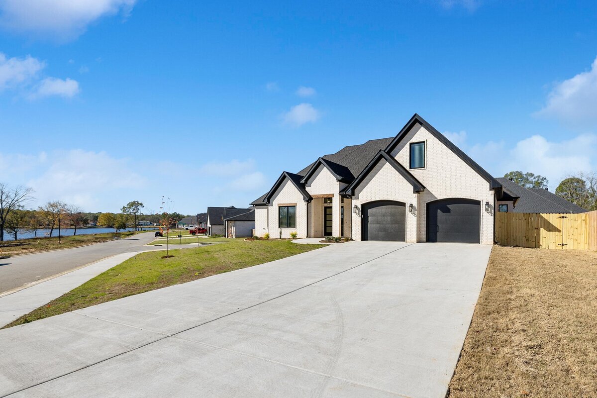 Front of 6011 Majestic Waters. White house with black trim and wood details.