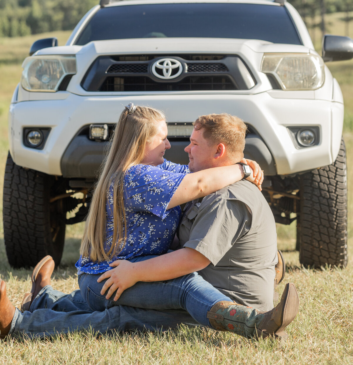 engaged couple sitting in field in front of truck by Atlanta Georgia engagement photographer Amanda Richardson Photography