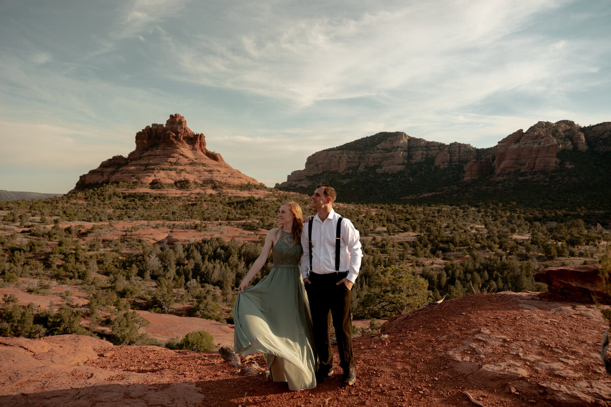 Couple standing against red rock backdrop during Sedona engagement session