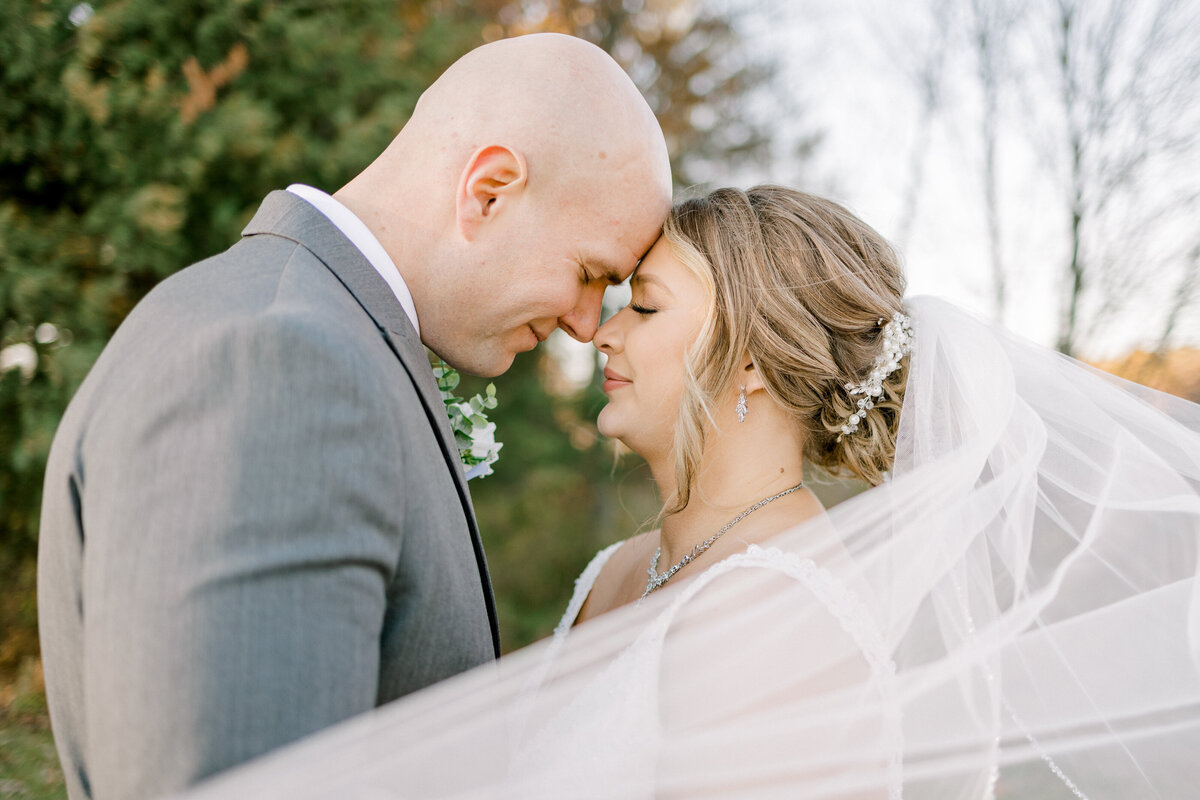 bride and groom facing each other touching foreheads