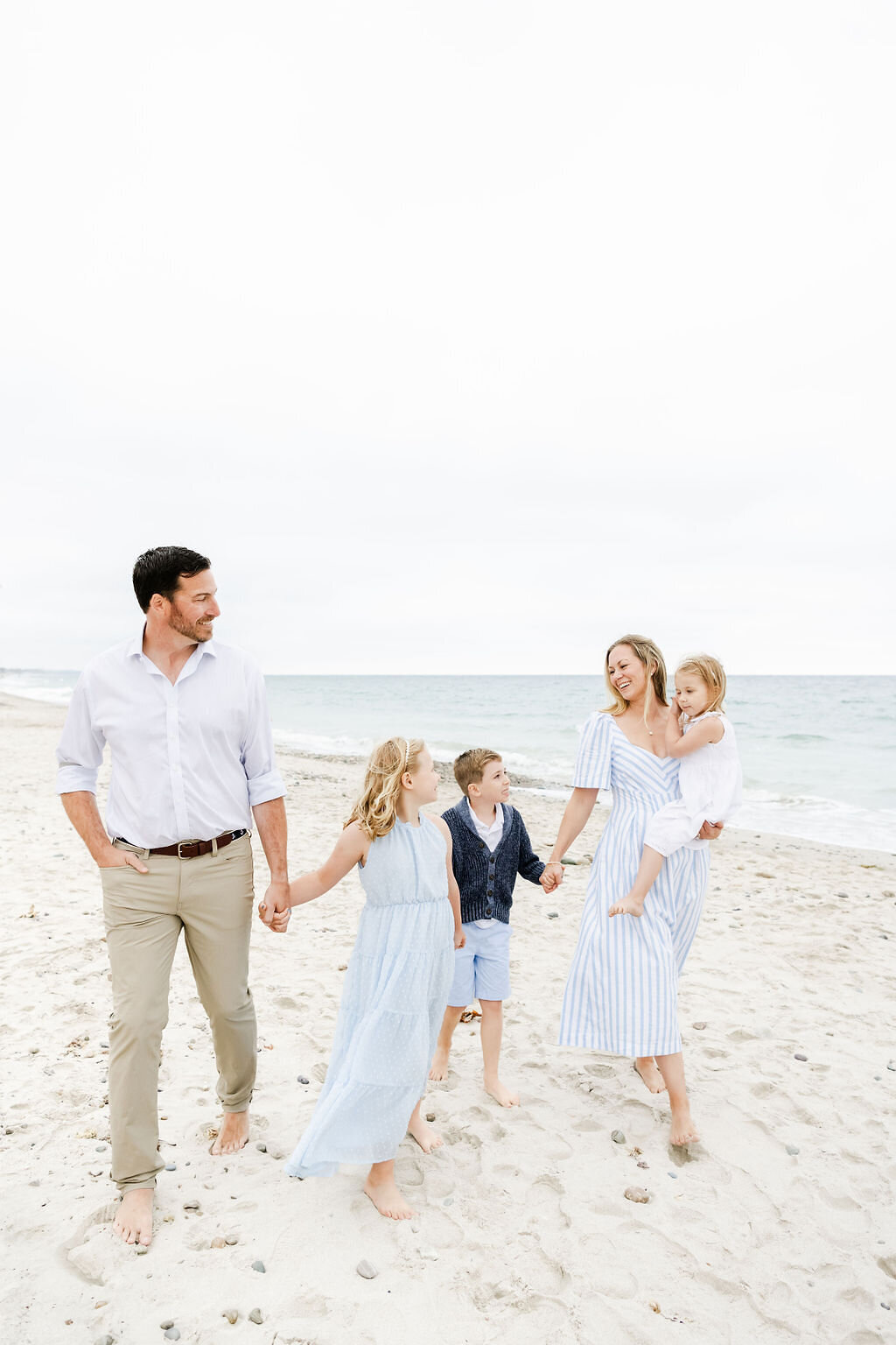 Family walking the beach holding hands