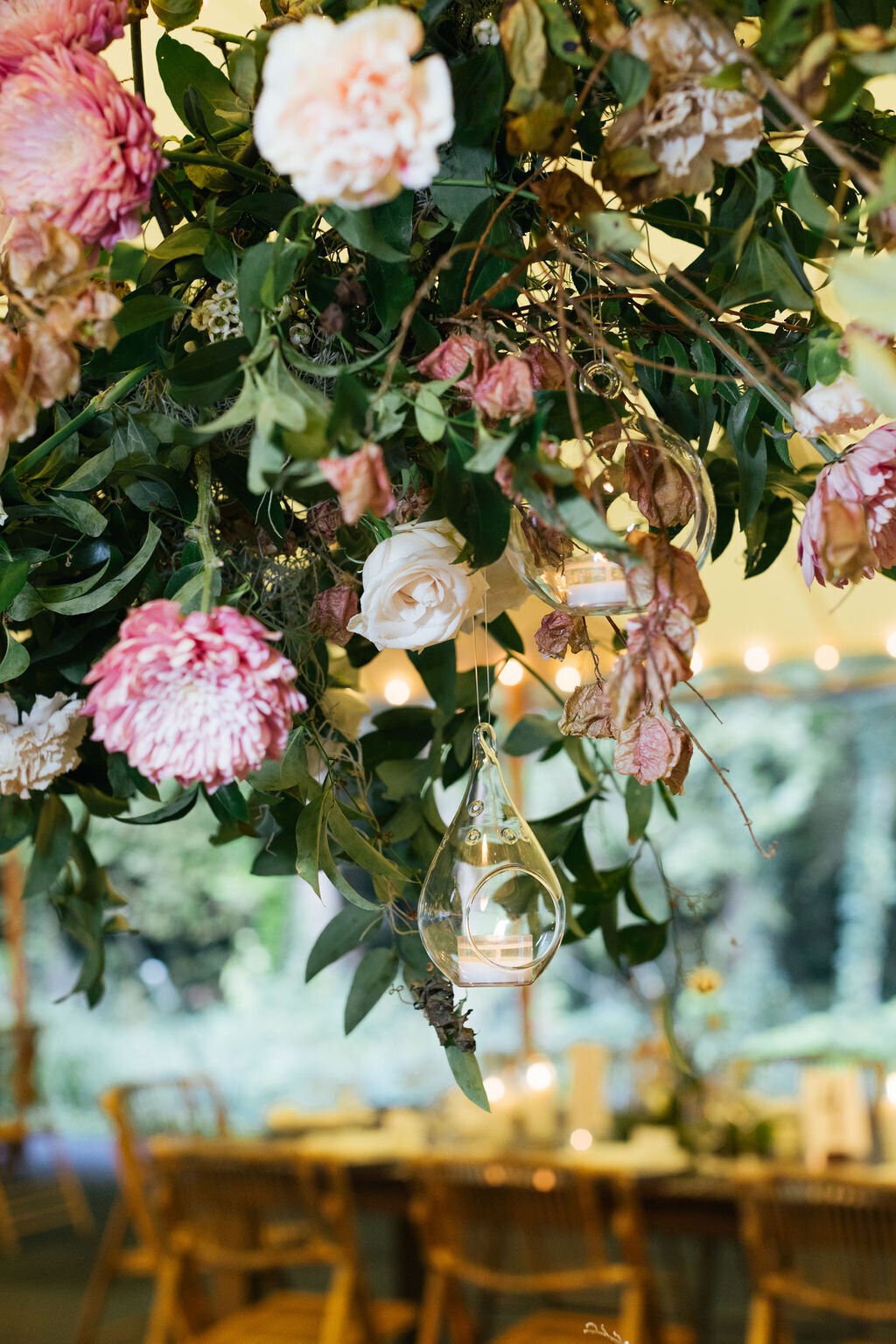 Autumn inspired hanging floral installation featuring hanging tea lights, lush natural greenery and roses. Wedding floral design at RT Lodge by Rosemary and Finch in Nashville, TN.