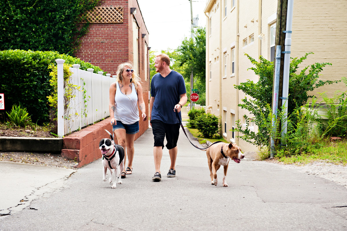 A newly engaged couple walking their dogs in downtown wilmington.
