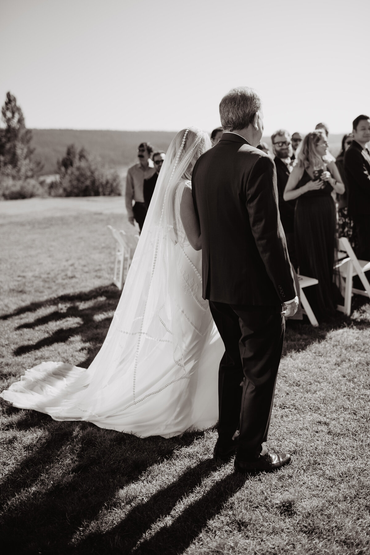 Photographers Jackson Hole capture bride walking down aisle in black and white portrait