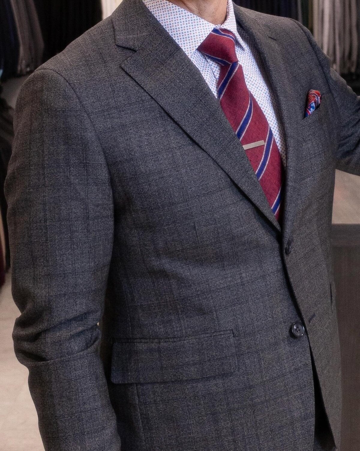 A man showing off men’s business formal fashion trends on a table in a clothing store