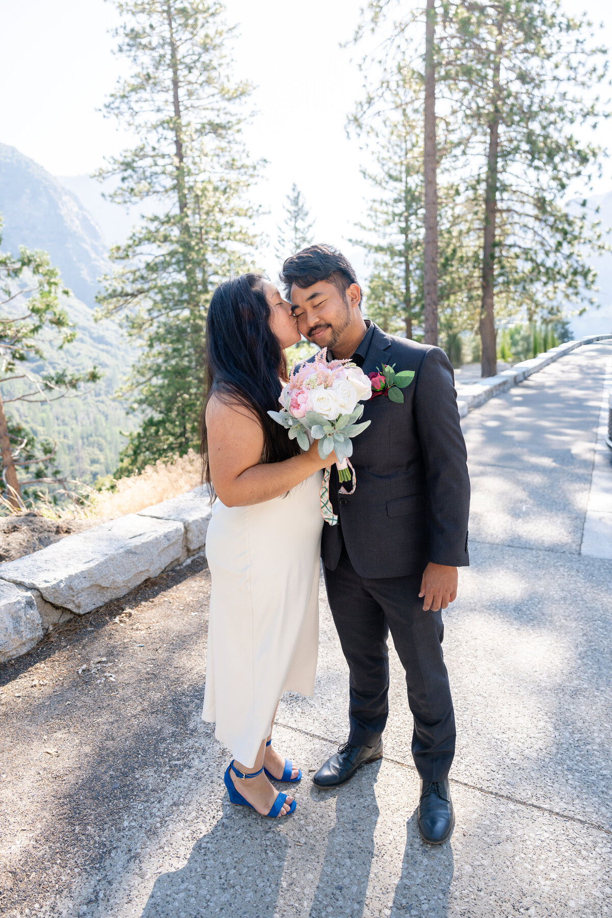 Bride and Groom eloping at Yosemite elopement at Tunnel View and kissing.