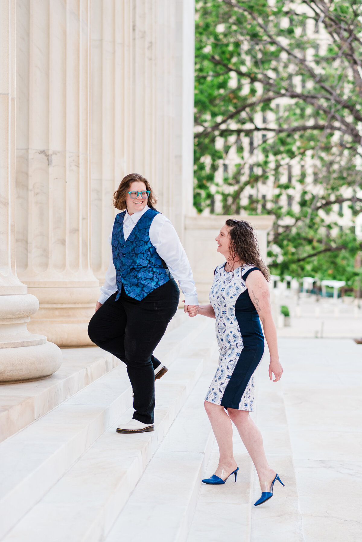 A couple walks up the Byron White Court house stairs while holding hands, captured by Denver wedding photographer KB Radiant photography