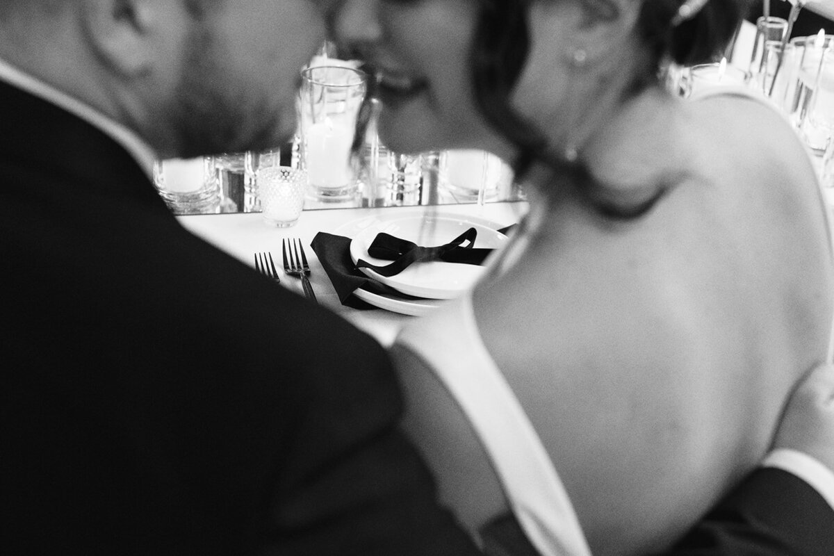 A close up of a bride and groom embracing.
