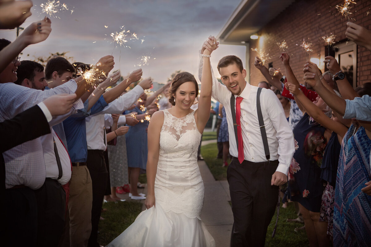 bride and groom walking through sparklers