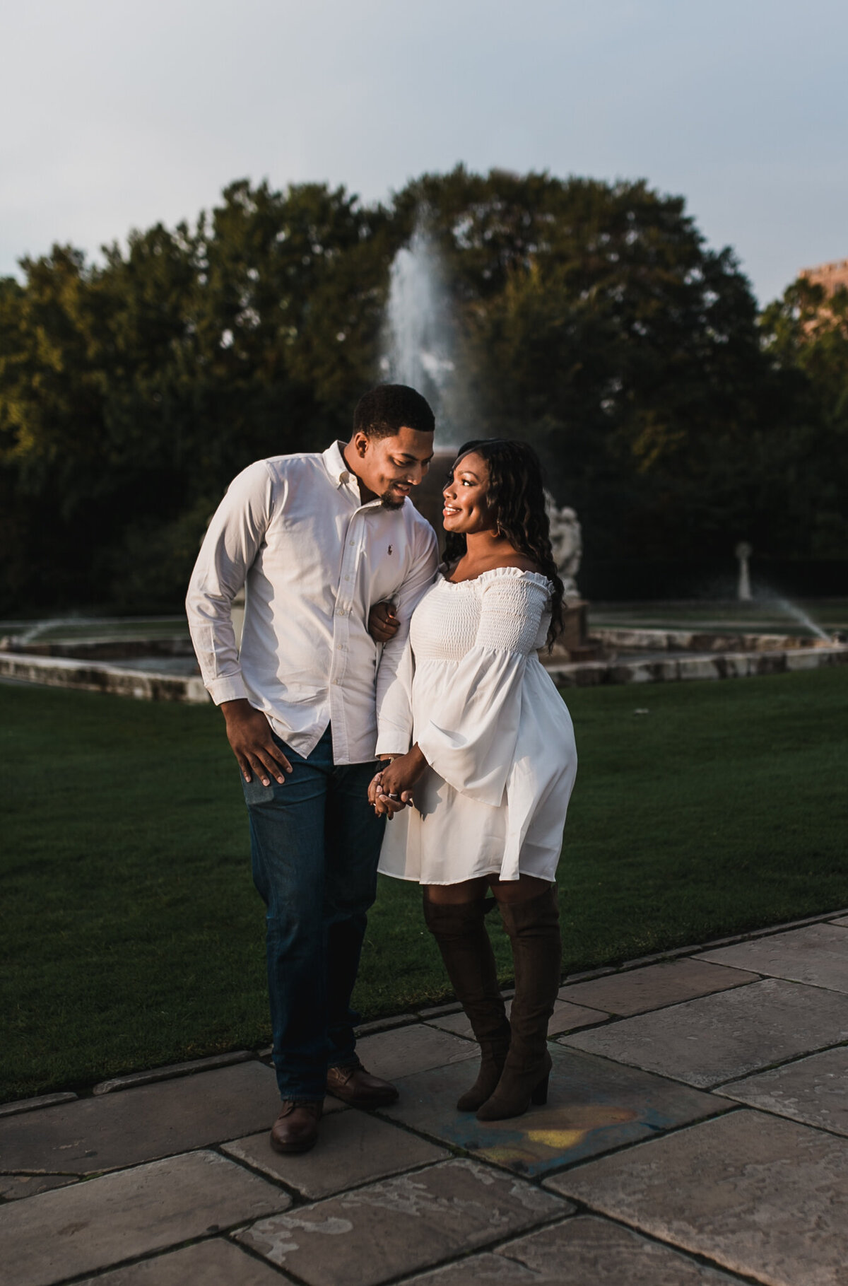 Pregnancy photoshoot with soon to be mom and dad holding hands outside.