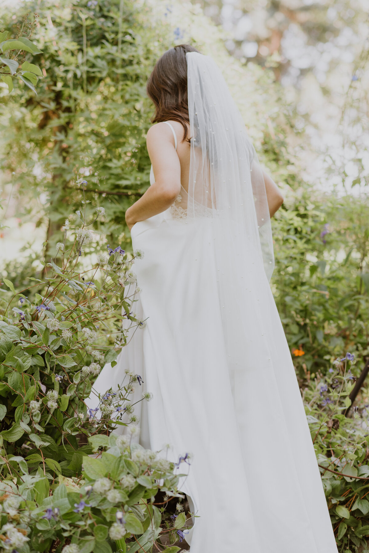 Bride walking up steps in garden