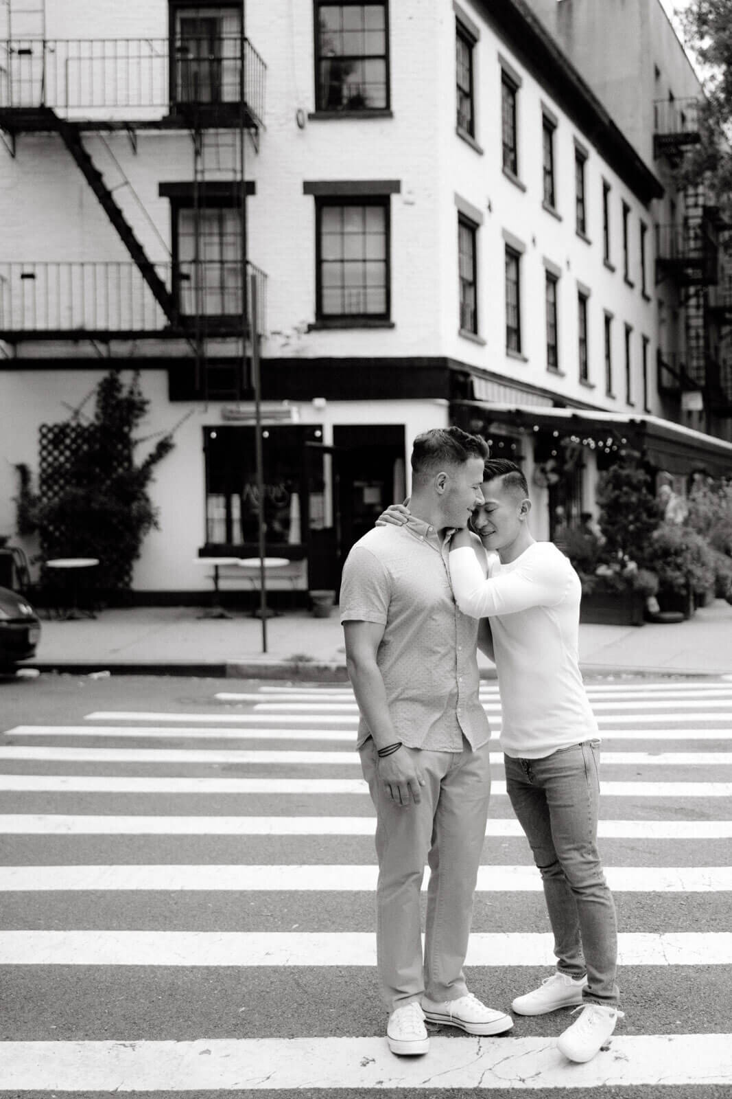 The engaged couple is lovingly standing in the middle of a pedestrian lane in West Village, NYC. Image by Jenny Fu Studio