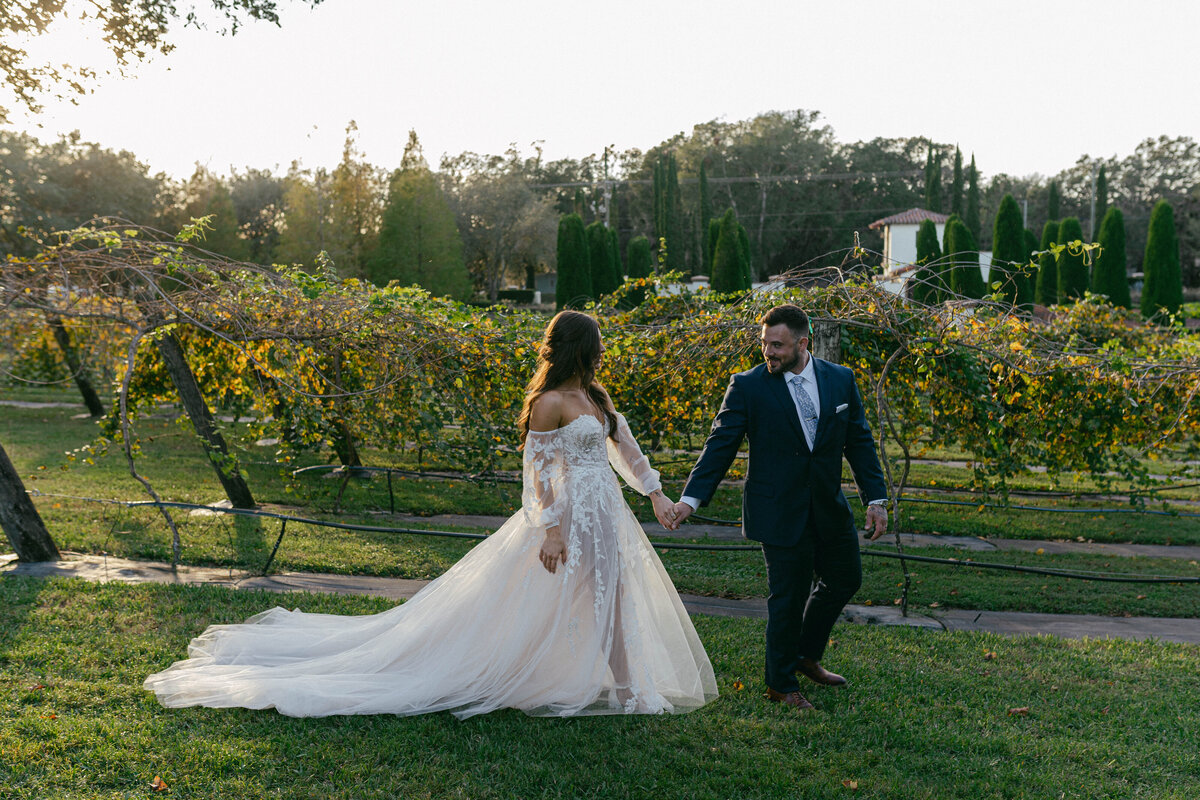 florida wedding photographer taking photos of bride and groom during sunset in  Mision Lago estate vineyards