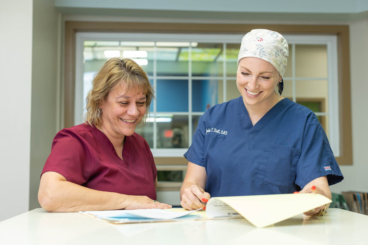 Two smiling female doctors reviewing a chart together