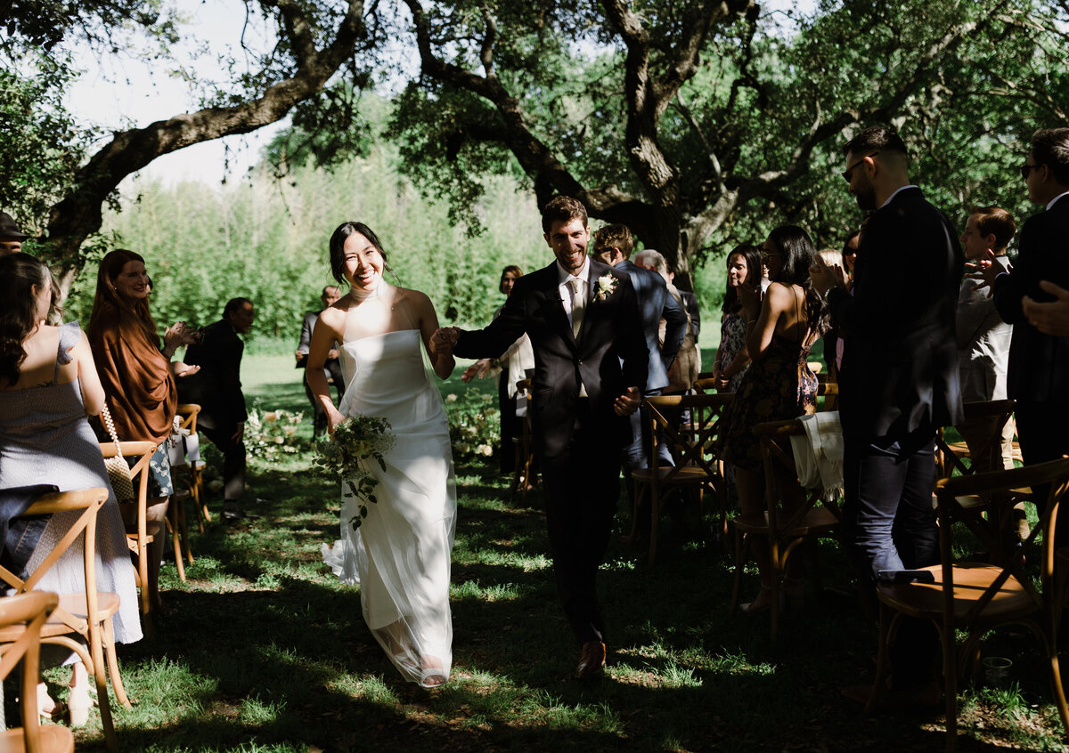 Bride and groom walking down the aisle after outdoor wedding ceremony at  Mattie's Austin