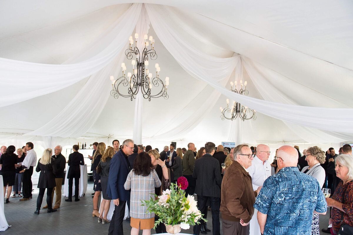 Ottawa event photography showing a room of attendees in tented corporate anniversary celebration.  Captured by JEMMAN Photography COMMERCIAL