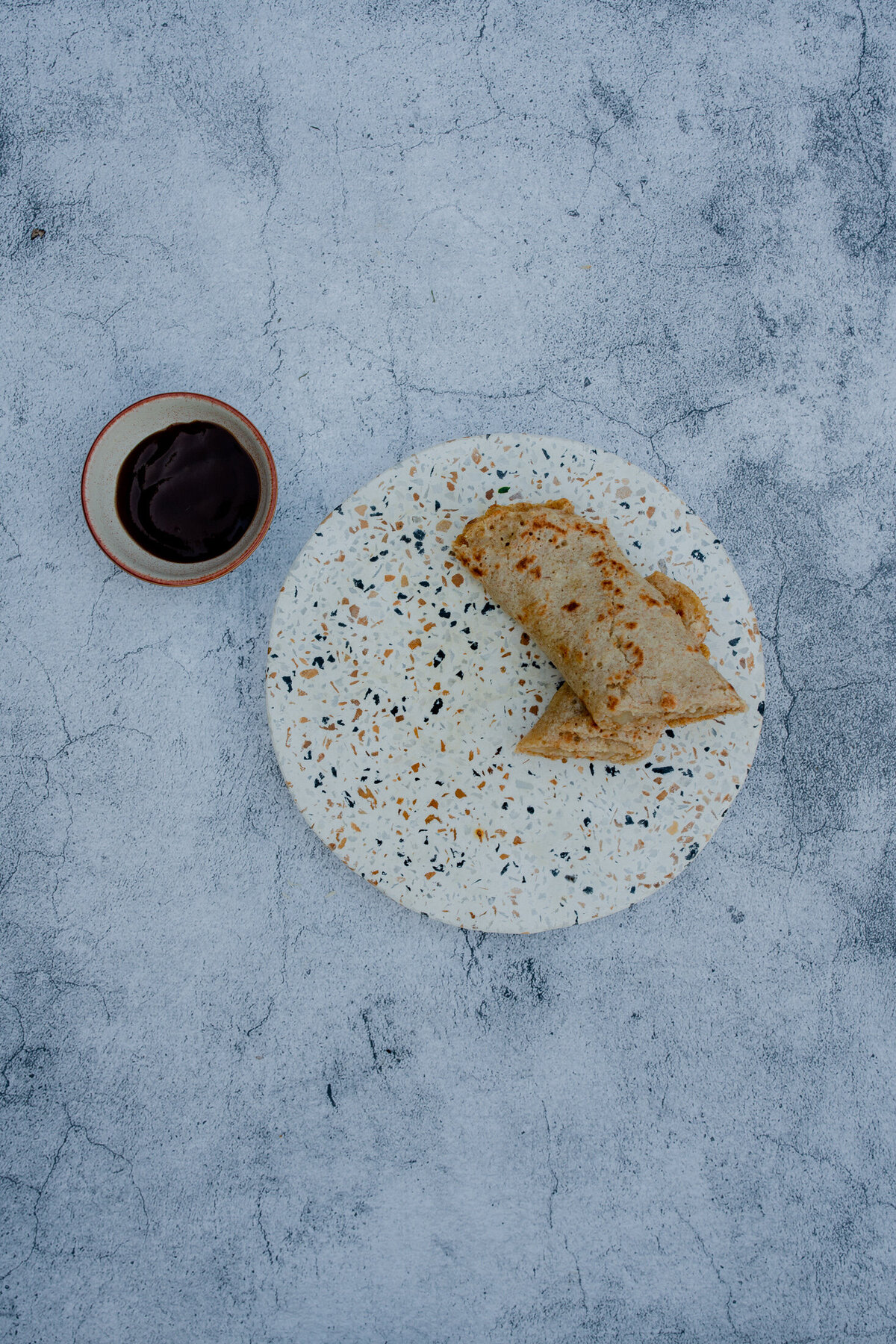 photography of a staffordhire oatcake with a side of brown sauce