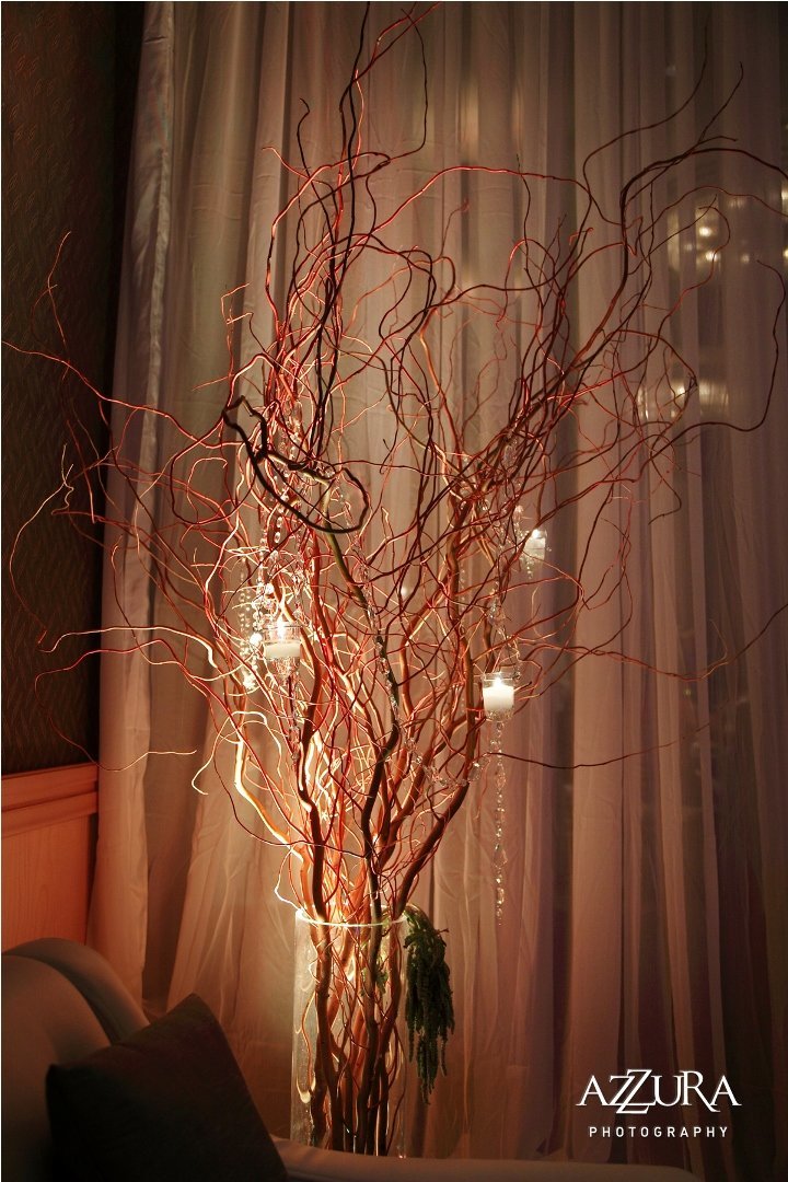 tall curly willow in tall glass vase with hanging candles