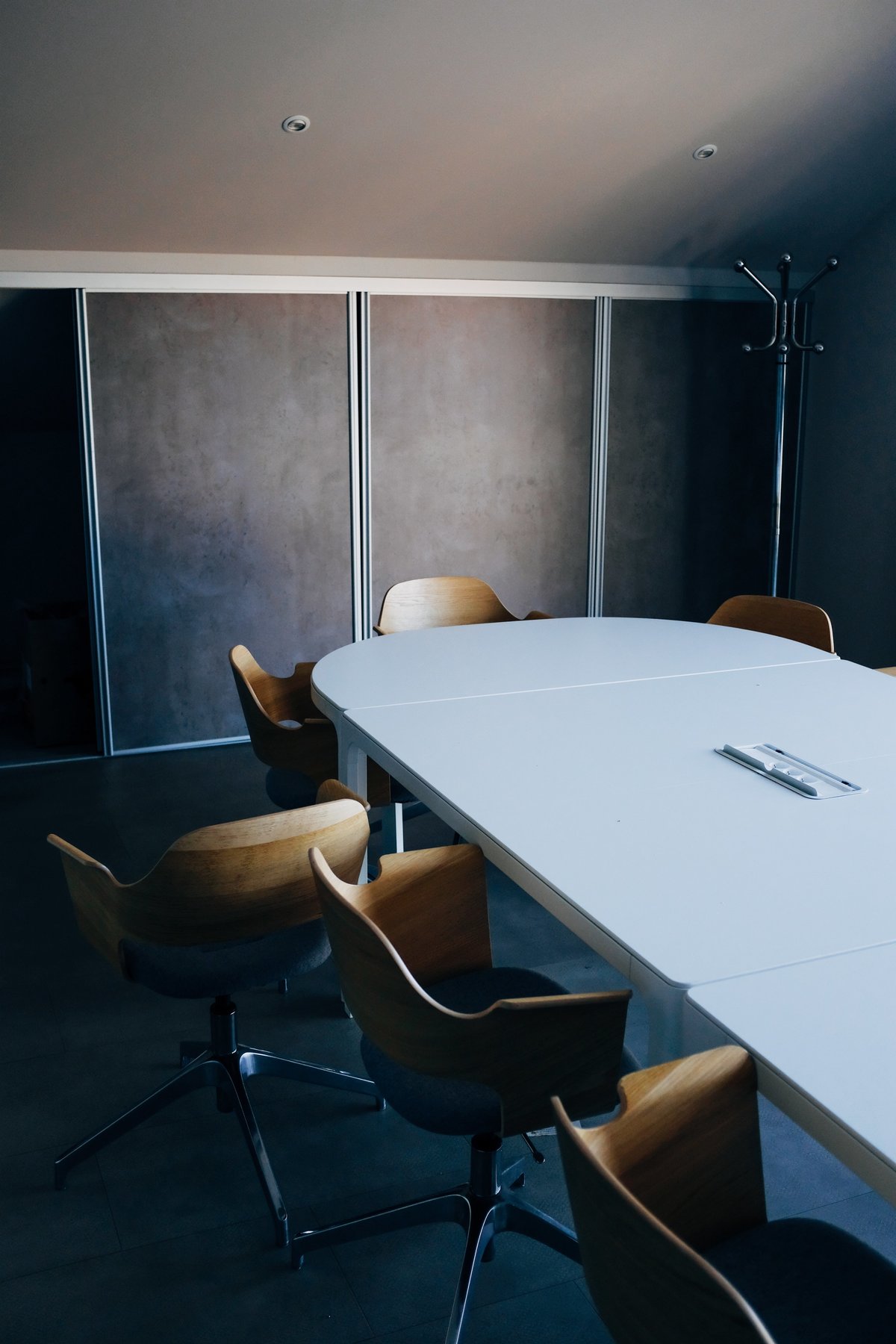 Wooden chairs  gathered around a  conference table in a modern conference room