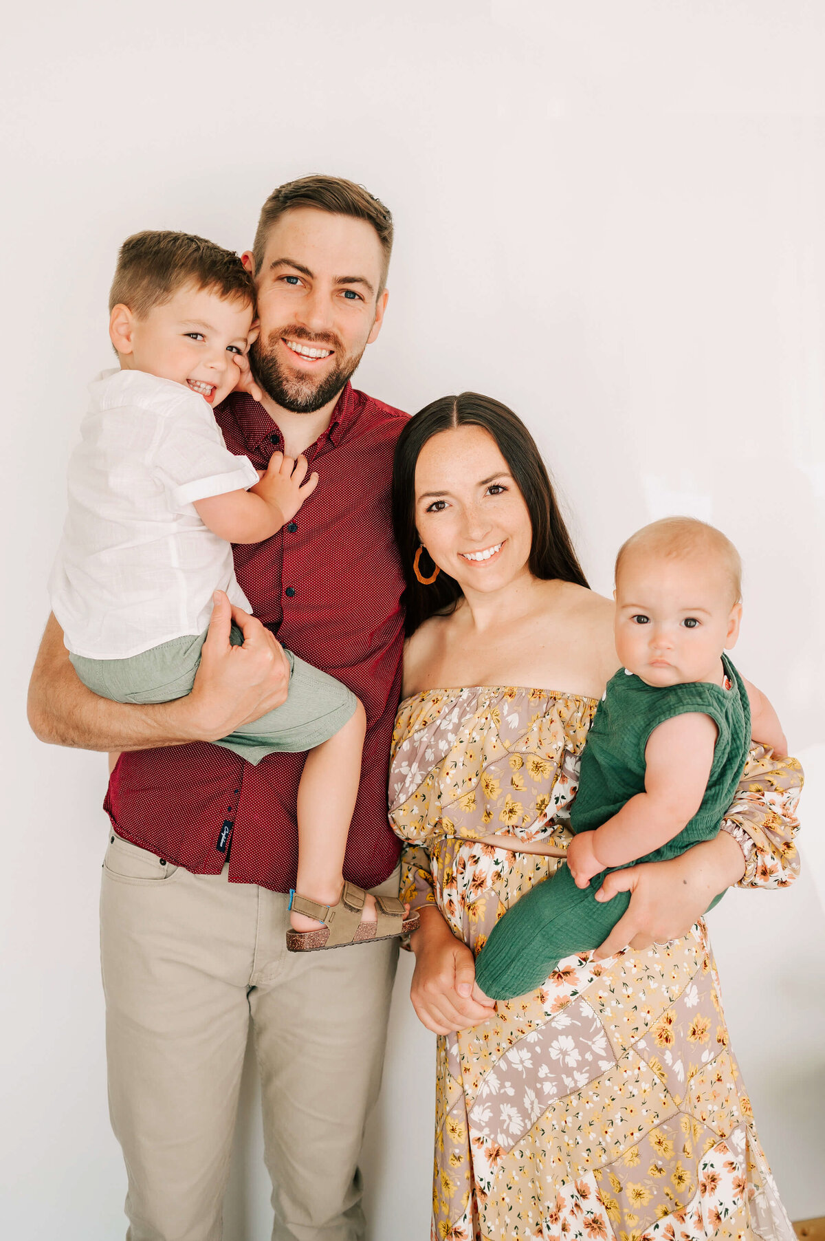 Family standing and smiling in family photography studio in Branson