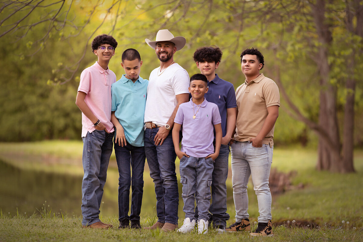 A family portrait session by a Dallas family photographer, capturing a father with his sons by the water in Dallas.