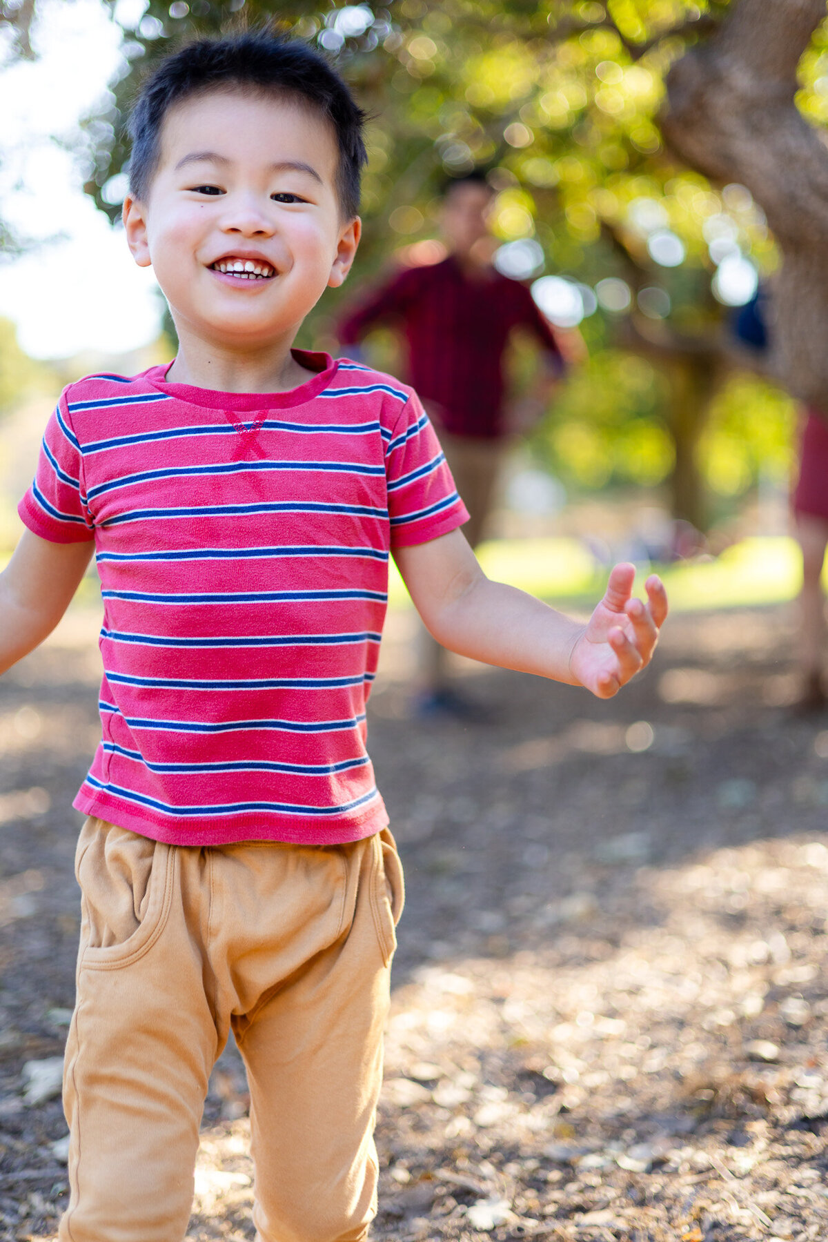 Smiling boy in striped shirt playing under trees at school playground – Bay Area School Photography Lifestyle – Ellobelle Photography
