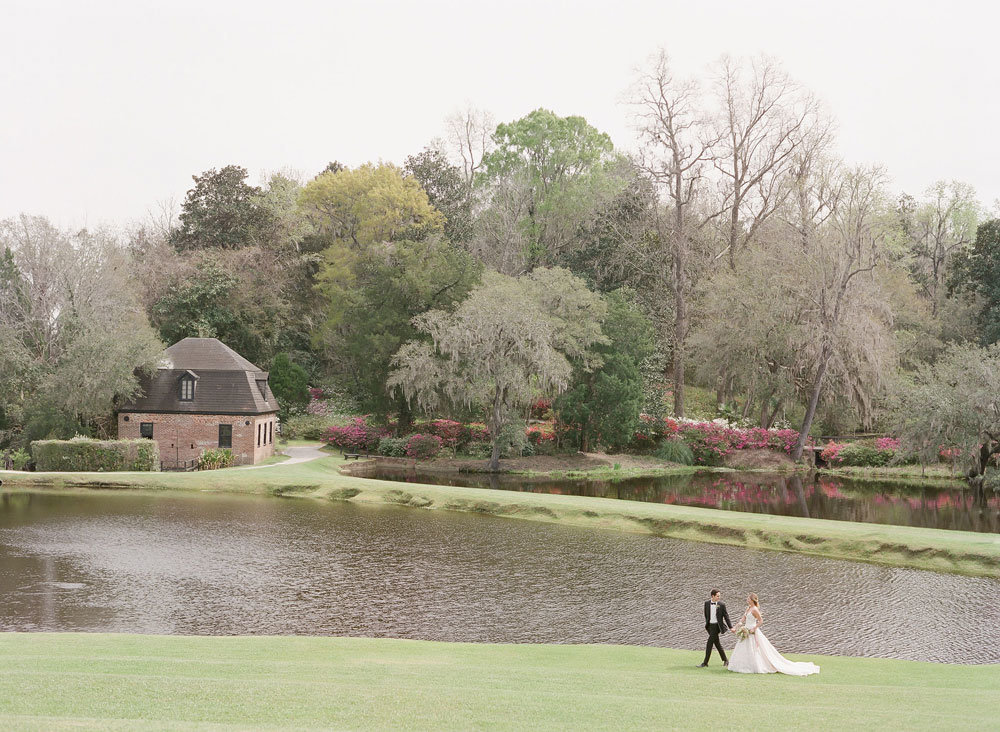 Married couple walking by the lake at Middleton Place, wedding venue in Charleston, SC