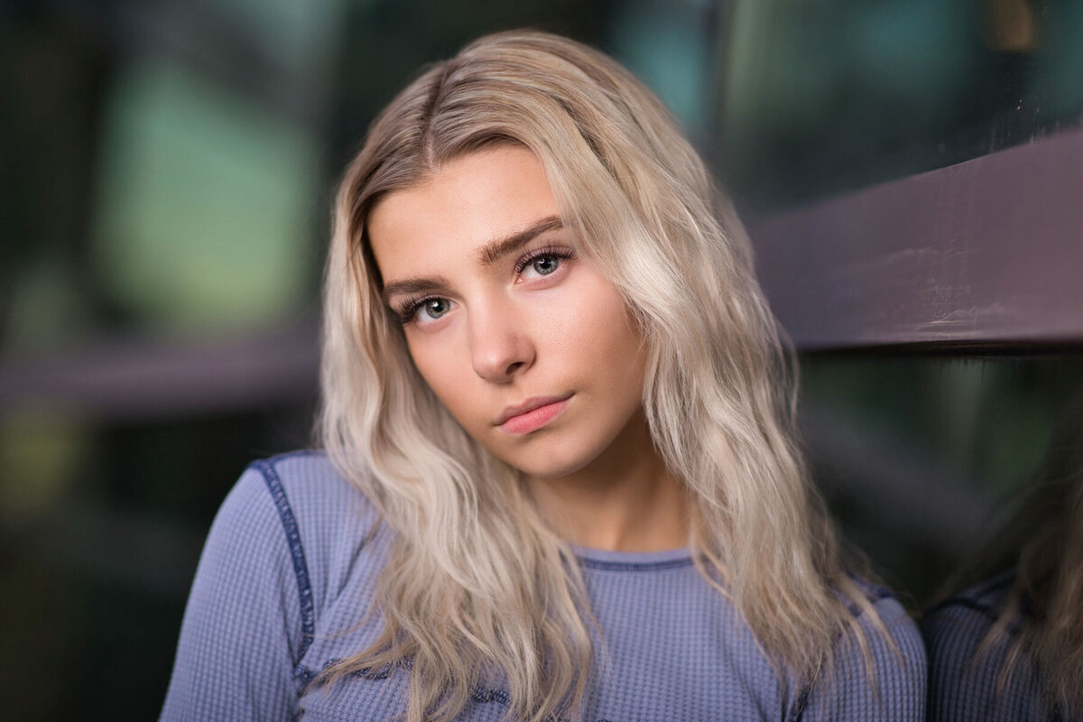 Senior girl posing for portraits in urban setting in Utah around sunset.