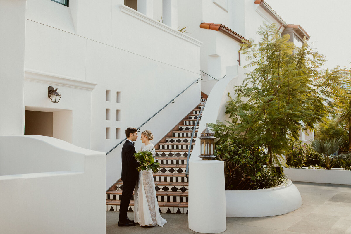 bride-looking-at-groom-at-white-staircase