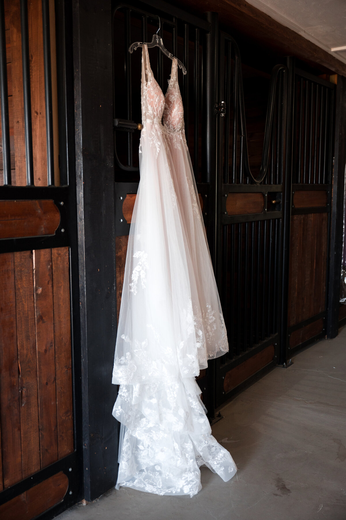 wedding dress hanging in a stable