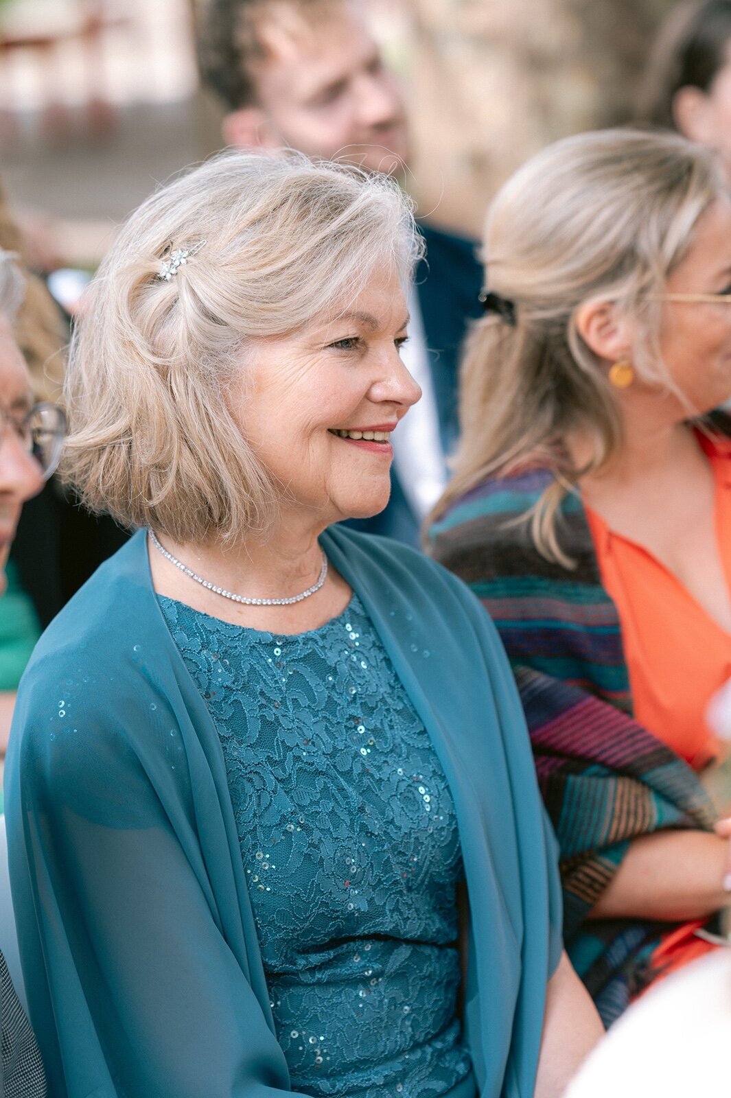 Foto van de moeder van de bruid terwijl ze lacht tijdens de ceremonie