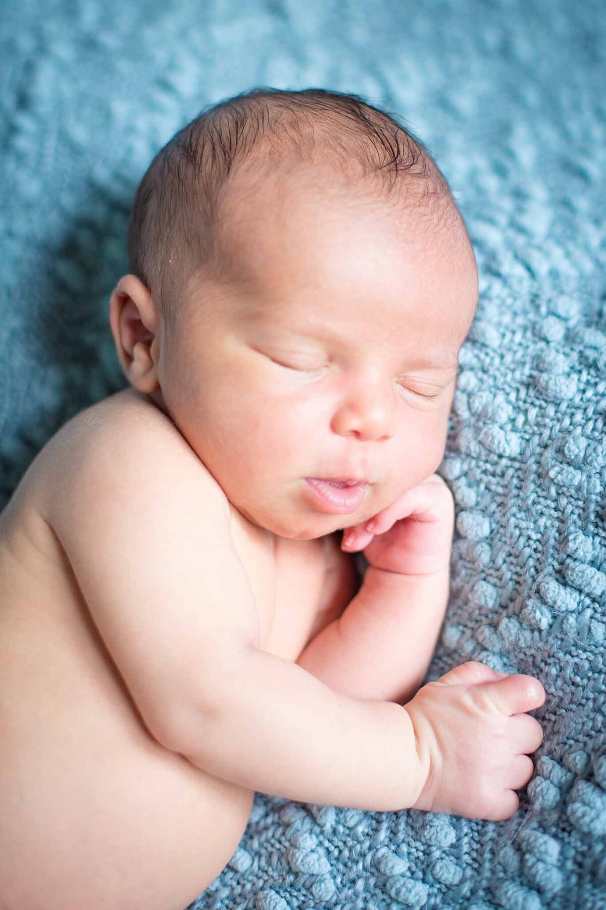 Newborn baby sleeping on a teal blanket in Columbia, SC